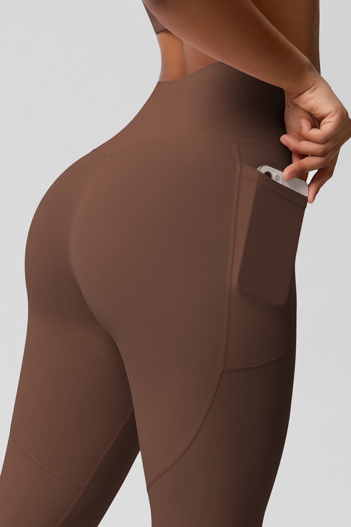 Nærbillede af sidelomme på leggings med mobiltelefon – fokus på funktionel detalje.


