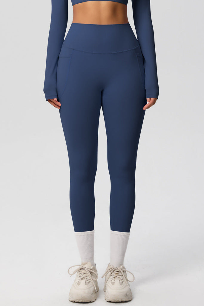 Model i blå leggings – set bagfra med lange ben og høj talje.

