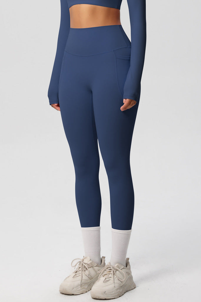 Model i blå leggings – set forfra fra knæ til talje.

