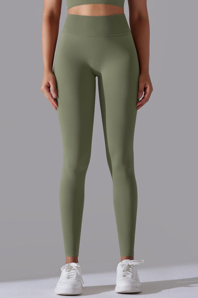 "Model iført grønne leggings – figursyet forfra med glat og sømløs finish"

